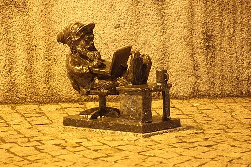 Programista the programmer dwarf sitting at a tiny computer desk